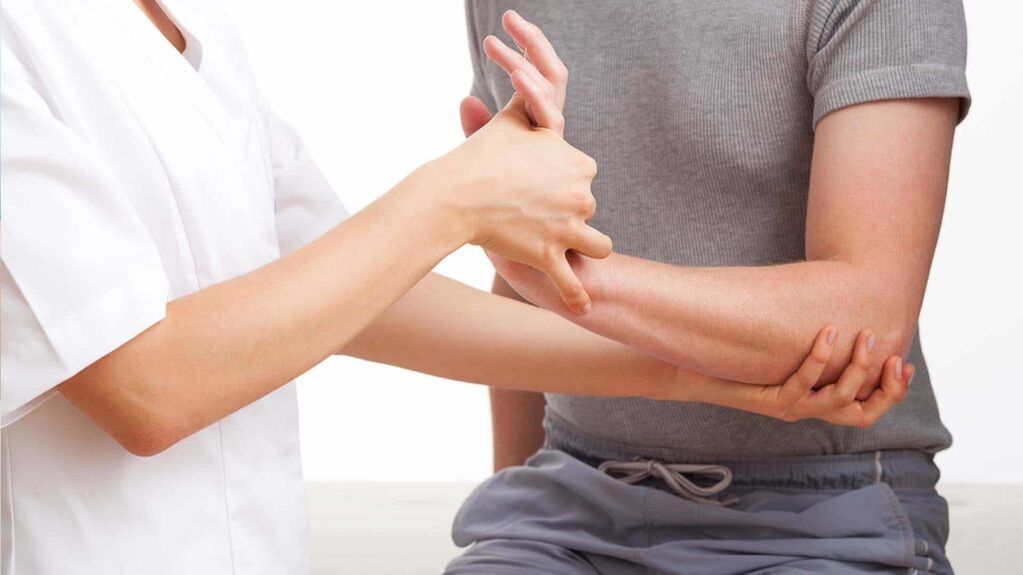 doctor examinando una mano con artritis